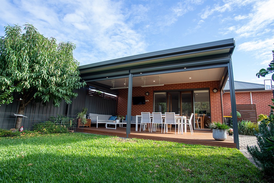 Charcoal patio over a timber deck with outdoor lounge and dining on a brick home
