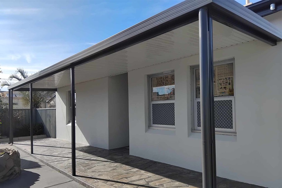 Flat charcoal Colorbond verandah along the side of a rendered home