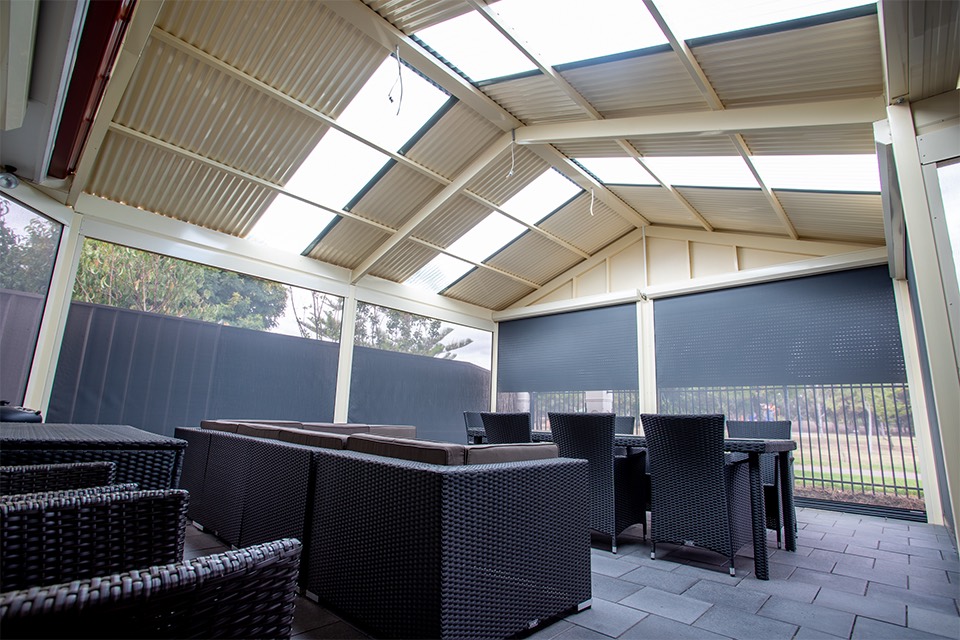 Gable verandah with polycarbonate roof lights and outdoor blinds over an outdoor lounge