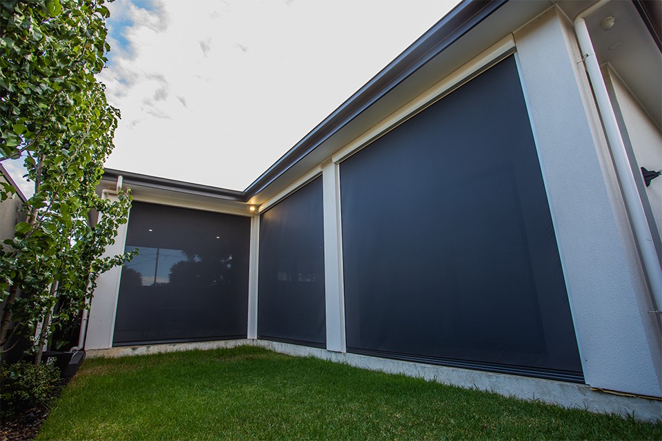 Charcoal mesh outdoor blinds enclosing an alfresco area