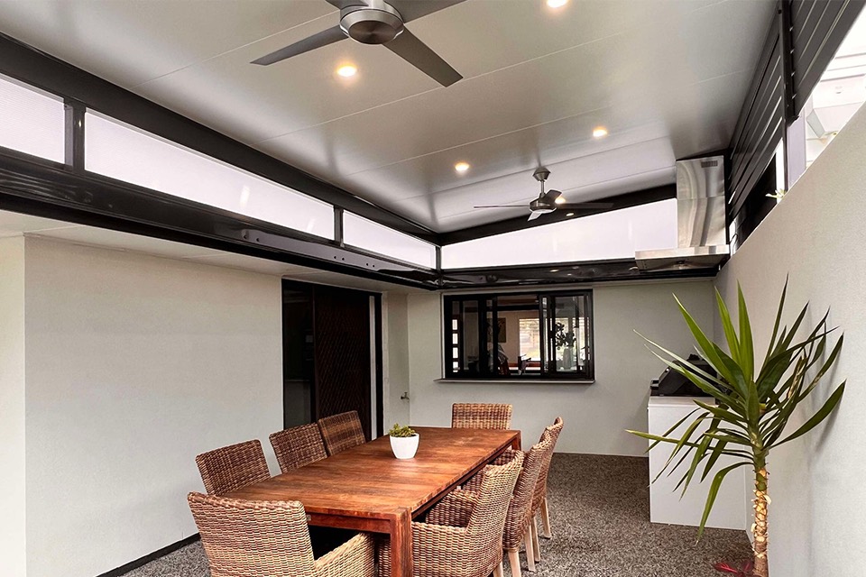 Patio with a smooth insulated ceiling, downlights and ceiling fans over an outdoor dining table