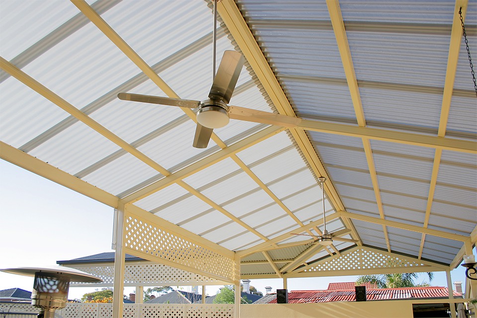 Steel pergola with a polycarbonate roof and ceiling fans